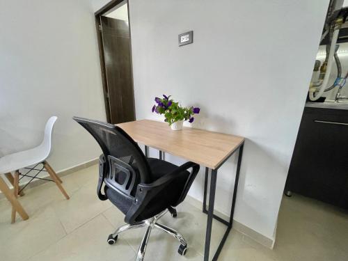 a table and a chair with a vase of flowers on it at Loft Boutique Rooftop I Gym I Laureles I MedView in Medellín