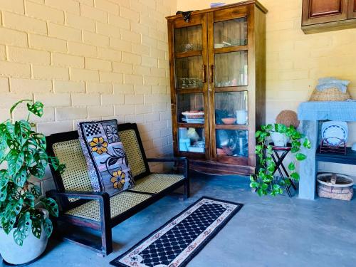 a patio with a chair and a cabinet and plants at Ashok villa in Weligama