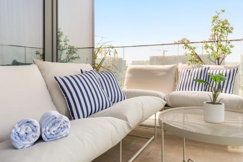 a living room with two white couches and a table at Bright Oasis at Yas - Private Beach Access in Yas Island