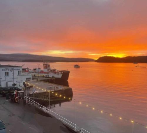 a boat docked at a dock with a sunset at The Lookout in Tobermory
