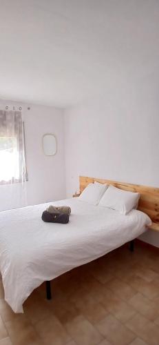 a bedroom with a white bed with a wooden headboard at LA CARA NORD , ALOJAMIENTO TURISTICO ,SALDES, A LOS PIES DEL PEDRAFORCA, apartamento in Saldés
