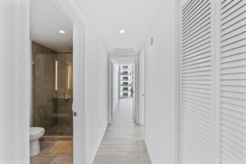 マイアミにあるDowntown Miami Luxe Studio Suiteの白い壁の廊下、バスルーム(トイレ付)