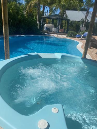 a hot tub in a swimming pool with blue water at Villa CHELSEA in Vilamoura