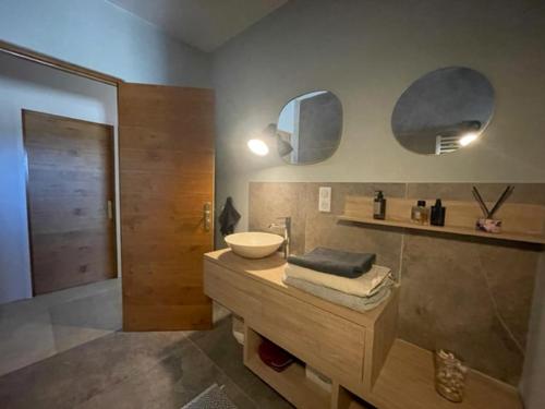 un baño con lavabo y espejo en Maison authentique 4 à 10 personnes, en Ersa