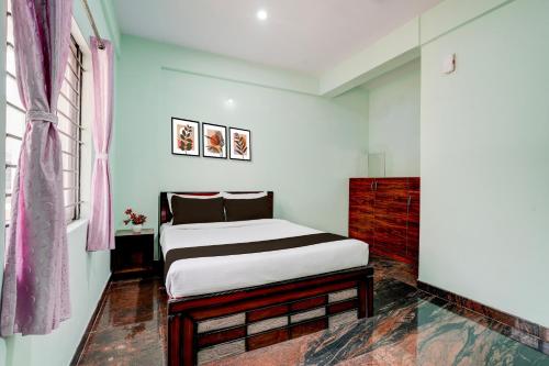 a bedroom with a bed and a window at Hotel O Nature Comforts in Bengaluru