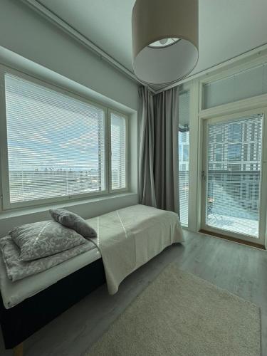 a bedroom with a bed and a large window at Pramea Apartments Matkatupa in Kuopio