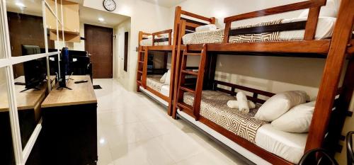 2 Etagenbetten in einem Zimmer mit einem Schreibtisch in der Unterkunft 517 New Brenthill Premium Condo Near SMBaguio in Baguio City