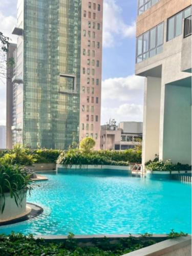 a swimming pool in the middle of a building with tall buildings at YAKA Trizen Luxury Apartments - 53rd and 51st Floor with Stunning Views in Colombo