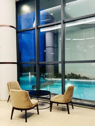 a swimming pool in a building with two chairs at YAKA Trizen Luxury Apartments - 53rd and 51st Floor with Stunning Views in Colombo