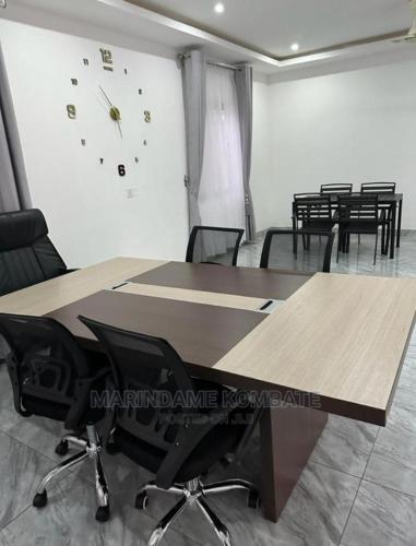 a room with tables and chairs and a clock on the wall at Phil homes in Apenkwa