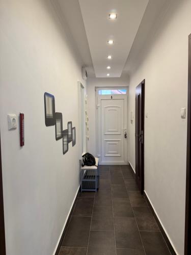 a hallway with a white door and a tile floor at Jégmadár Apartman in Gyula
