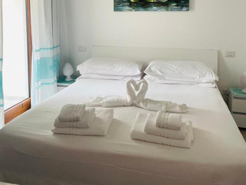 a white bed with towels on top of it at Blumarine in Palau