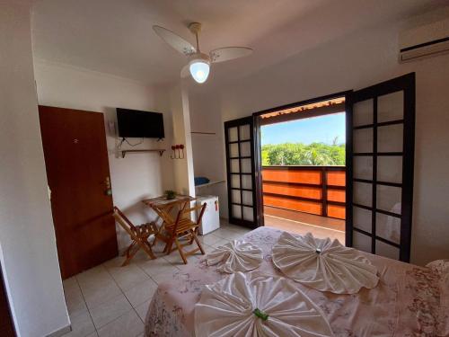 a bedroom with a bed and a view of a balcony at Pousada Costa dos Corais in Mangaratiba