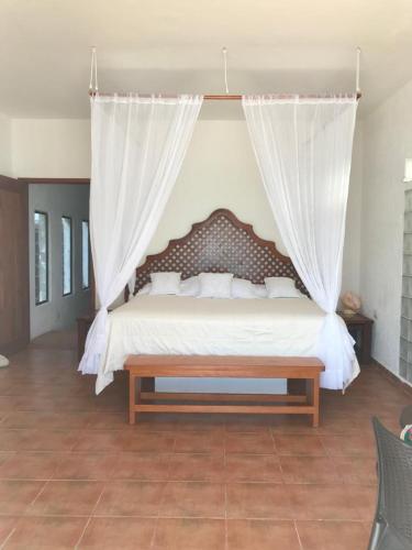a bedroom with a large bed with a canopy at House by the beach Casa Murmullos in Isla Mujeres