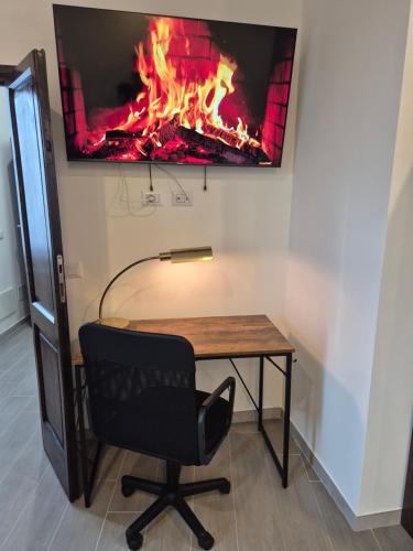 a desk with a chair and a fire on the wall at La Casa Dei Principi - B in Genazzano