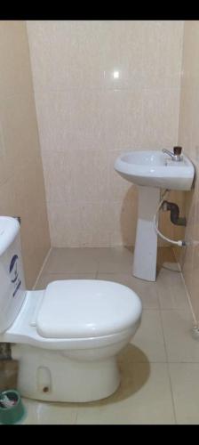 a bathroom with a white toilet and a sink at GA guest House in Ibadan