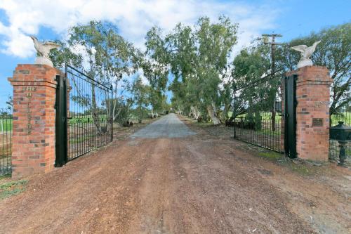 a gate with two birds on top of it on a dirt road at Hillside Country Retreat in York