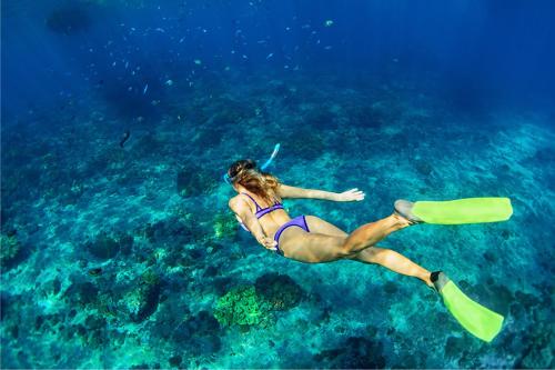 a woman in a bikini swimming in the ocean at Genge Lake Resort - Kalpitiya in Pallivasalturai