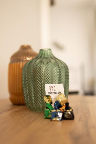 a green vase sitting on top of a wooden table at La Gitanilla Alojamiento & Encanto Jerez in Jerez de la Frontera