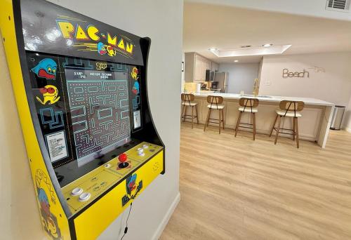a video game machine in a room with a bar at Grand Beachfront Paradise - Ocean & Pool View in South Padre Island