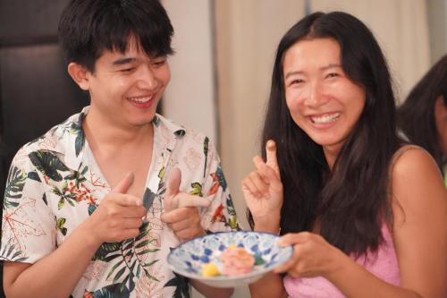 a man and a woman holding a plate of food at Comfort Hostel Phuket Old Town by MaTong in Phuket Town