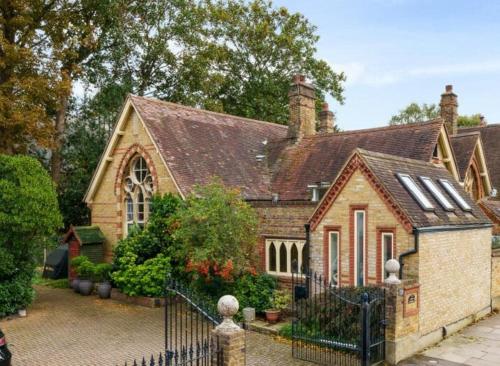 a large brick house with a black fence at School Cottage conversion in Grove Park