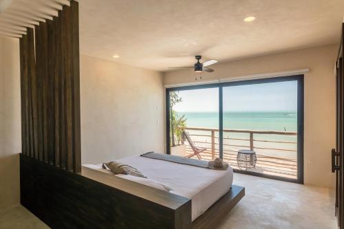 a bedroom with a bed and a view of the ocean at AWA Holbox Hotel Boutique - Beach Front in Holbox Island