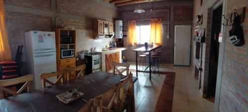 a kitchen with a table with chairs and a refrigerator at Cumbres del Sol in Albardón