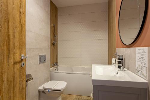 a bathroom with a sink and a toilet and a tub at Sika Prestige Apartment - cazare premium Arad - self check-in in Arad