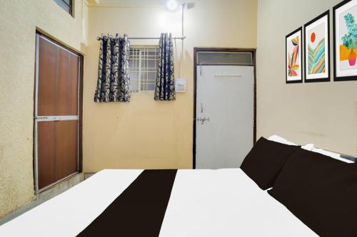 a bedroom with a bed and a door and a window at SPOT ON Hotal Krishna in Dīp