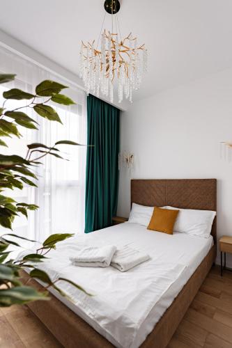 a bedroom with a large bed with a chandelier at Sika Prestige Apartment - cazare premium Arad - self check-in in Arad