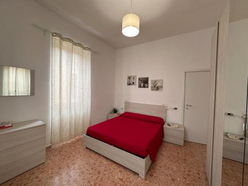 a bedroom with a red bed and a bathroom at House 130 Francavilla B&B in Francavilla al Mare