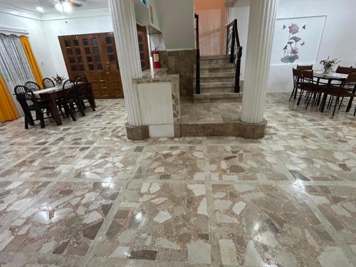 a room with a stone floor with tables and chairs at G Apartment - Standard Room in Binicuil