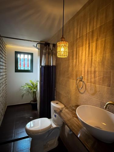 a bathroom with a white toilet and a sink at Alma House in Monguí