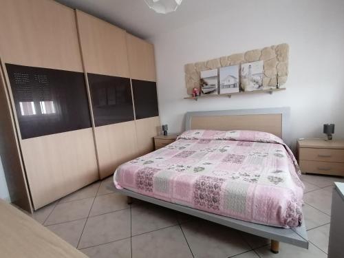 a bedroom with a bed with a pink comforter at Il Piacere di Casa - Appartamento a Porto Viro in Porto Viro