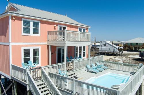 a house with a large deck and a swimming pool at Wave Loudest, Private Pool, Beach in Dauphin Island