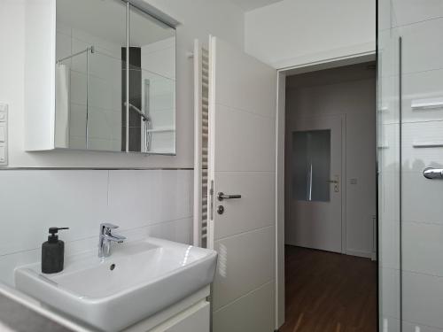 une salle de bain blanche avec un lavabo et un miroir dans l'établissement Charmante Ferienwohnung in Tecklenburg, à Tecklembourg