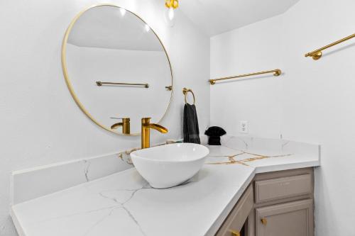 a white bathroom with a sink and a mirror at Grand Beachfront Paradise - Ocean & Pool View in South Padre Island