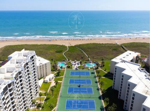 an aerial view of the beach and buildings and tennis courts at Grand Beachfront Paradise - Ocean & Pool View in South Padre Island