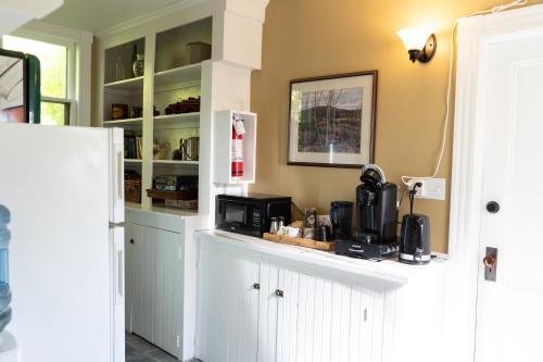 a kitchen with white cabinets and a microwave at Dominion Hill Country Inn in Bocabec