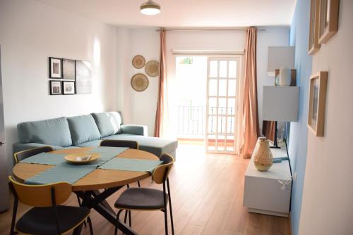 a living room with a table and a couch at Casa Mirasol in Playa de San Juan