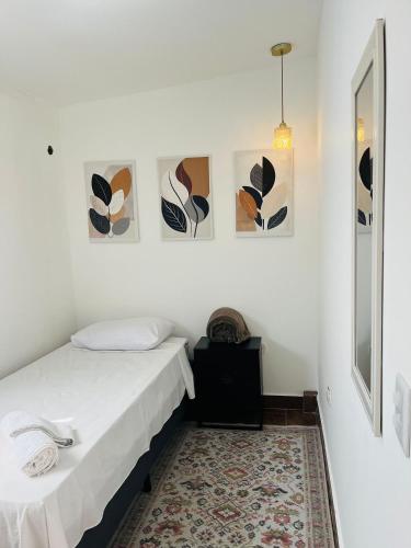 a bedroom with a bed and some pictures on the wall at Airport Stay Guarulhos – 600m Bosque Maia, Wi-Fi, Estacionamento, Sala de Espera, piscina, Check-in Facial in Vila Gopoúva