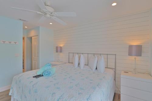 a white bedroom with a bed and a ceiling fan at Siesta Key Island Rentals in Siesta Key