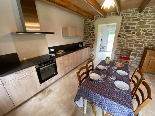 una cucina con un tavolo e sedie in una stanza di Maison Yvonne 