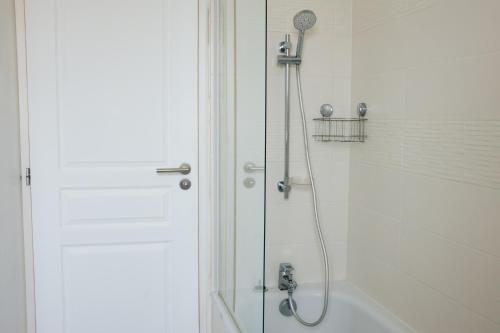 a shower with a glass door next to a bath tub at Maison de Saint-Jean in Fouesnant