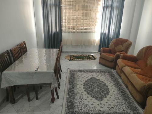 a living room with a table and chairs and a couch at Centre ville place in Tlemcen