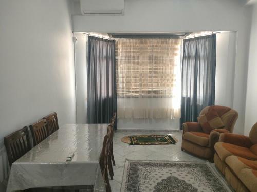 a living room with a table and a couch and a window at Centre ville place in Tlemcen