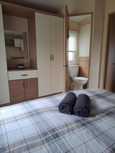 a bedroom with a bed with two towels on it at Three lochs holiday park Loch view 123 in Balminnoch