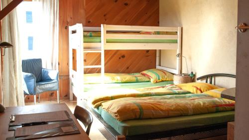 2 literas en una habitación con escritorio y mesa en BnB Solarhaus, en Aarberg