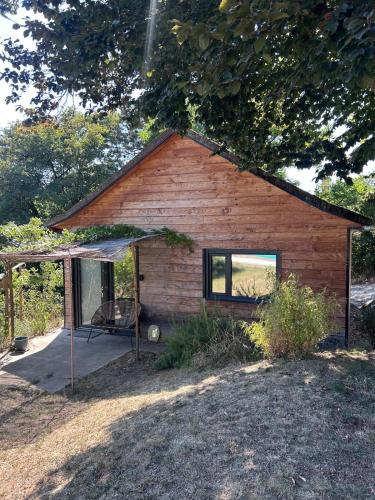 a log cabin with a chair in front of it at Le Chalet des Iris in Saint-Maurice-de-Gourdans